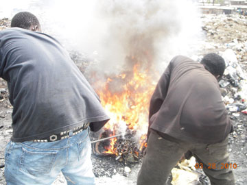 Boys stoke the fire containing the wires.