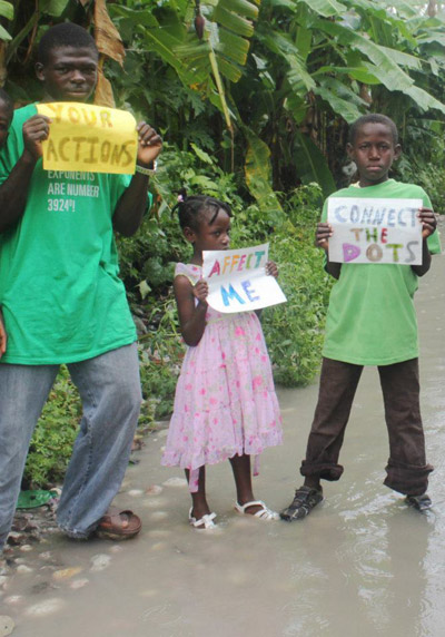 Haiti's youth stand in flooded streets to connect the dots between climate change and severe floods. Photo courtesy of 350.org.