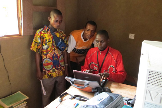 ISDR-Djolu computer technician working with students. Photo courtesy of: Ingrid Schulze.