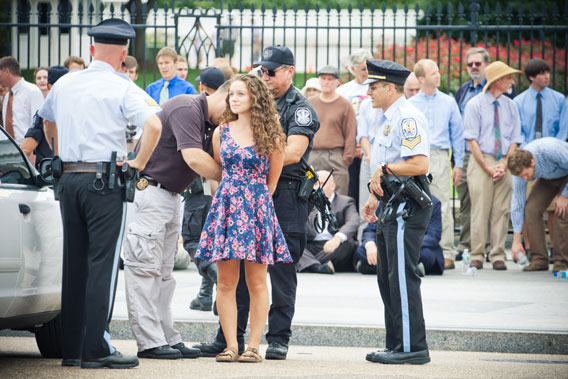 Young woman is placed in handcuffs and arrested in front of the White House.  